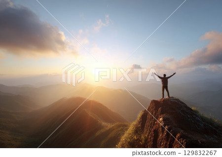 Person Standing on Cliff Edge with Arms Wide Open at Sunset 129832267
