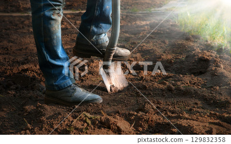 Man's feet with a shovel 129832358