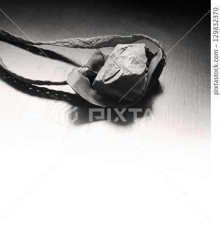 Sling with stone on wooden background Sling with stone on wooden background 129832370