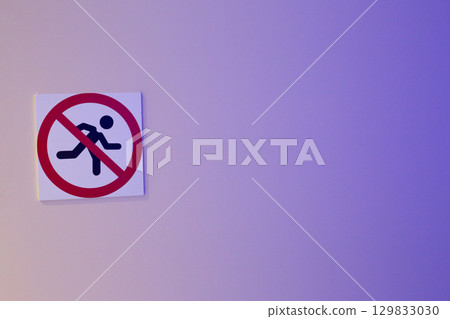 No running sign on light blue background. The symbol shows person running crossed out with red circle, enforce safety regulations in areas where running is prohibited 129833030