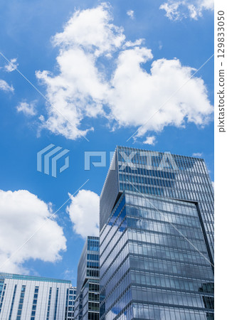 仰望摩天大樓間的藍天白雲 129833050