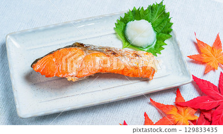 Grilled salmon with grated daikon radish, a scene of autumn leaves and Japanese cuisine 129833435