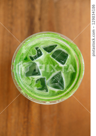 Cup of fresh matcha tea, green tea on wooden mat background. Cup of fresh matcha tea, green tea on wooden mat background. 129834186
