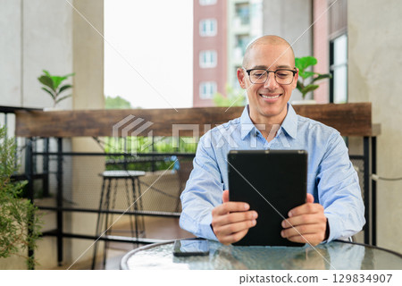 Businessman Using Tablet Computer Outdoors in Daylight 129834907