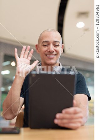Man using digital tablet computer while sitting in mall cafe, digital lifestyle and wellness Man using digital tablet computer while sitting in mall cafe, digital lifestyle and wellness 129834963