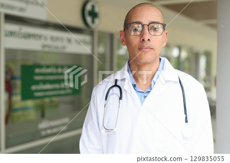 Doctor Standing Outside Medical Clinic Wearing White Lab Coat 129835055