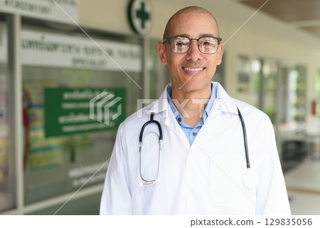 Doctor Standing Outside Medical Clinic Wearing White Lab Coat 129835056
