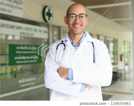 Doctor Standing Outside Medical Clinic Wearing White Lab Coat Doctor Standing Outside Medical Clinic Wearing White Lab Coat 129835061