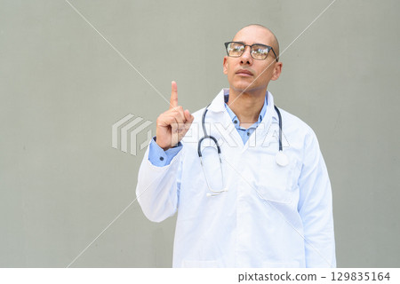 Hispanic Male Doctor in Lab Coat with Stethoscope on Plain Background 129835164