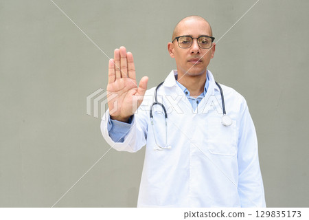 Hispanic Male Doctor in Lab Coat with Stethoscope on Plain Background Hispanic Male Doctor in Lab Coat with Stethoscope on Plain Background 129835173