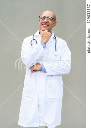 Hispanic Male Doctor in Lab Coat with Stethoscope on Plain Background 129835187