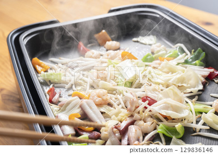 Seafood and vegetable stir fry on a hot plate 129836146