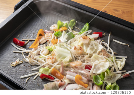 Seafood and vegetable stir fry on a hot plate Seafood and vegetable stir fry on a hot plate 129836150