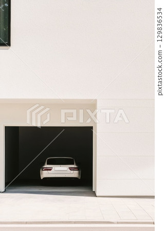 White luxury sedan parked inside minimalist garage, representing modern residential design and sophisticated urban lifestyle White luxury sedan parked inside minimalist garage, representing modern residential design and sophisticated urban lifestyle 129836534