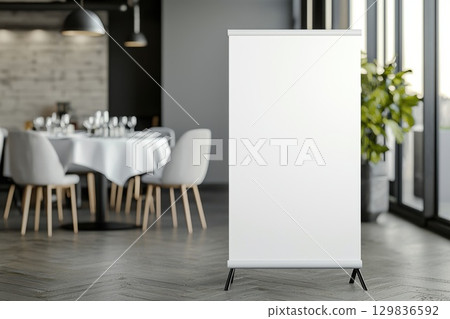 Blank roll up banner positioned near round table, modern restaurant setting with herringbone wood flooring, representing marketing display concept 129836592