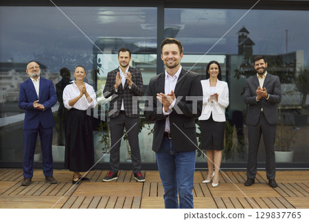 Team of corporate workers in formal clothing standing and clapping hands, meeting new colleague 129837765
