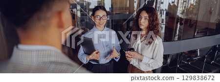 Participate in a dynamic business meeting in a modern office with high energy and collaboration Participate in a dynamic business meeting in a modern office with high energy and collaboration 129838672