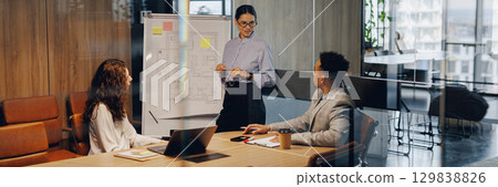 A dynamic meeting occurs in a modern office designed for collaboration and creativity 129838826
