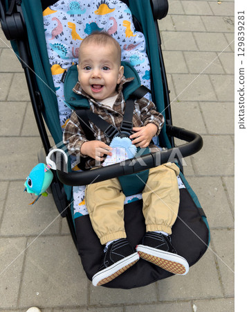 Smiling Baby in Stroller with Plaid Shirt 129839281