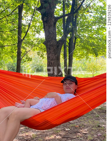 Mother and Baby Relaxing in Hammock Outdoors 129839286