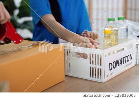 Volunteer organizing donations, contributing to community welfare Volunteer organizing donations, contributing to community welfare 129839303