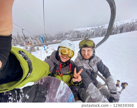 Ski Lift Adventure with Snowboarders Ski Lift Adventure with Snowboarders 129839308