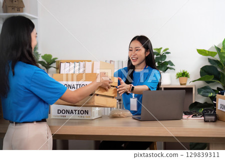 Volunteers teamwork exchanging donations at community center 129839311