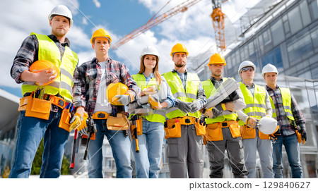 Group of construction workers wearing helmets and vests holding tools. for labor and building themes. Group of construction workers wearing helmets and vests holding tools. for labor and building themes. 129840627