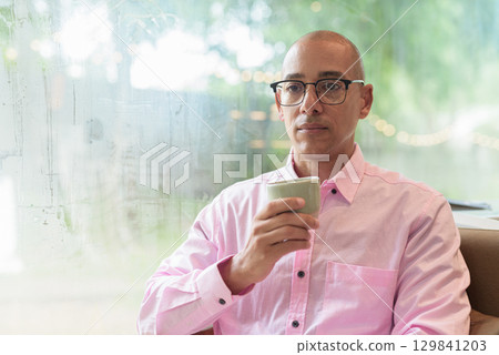Bald Hispanic man holding coffee cup in cafe restaurant 129841203