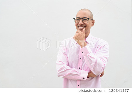 Bald Hispanic man wearing pink casual business shirt and eyeglasses thinking and looking up Bald Hispanic man wearing pink casual business shirt and eyeglasses thinking and looking up 129841377