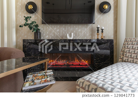 Modern Fireplace with Black Marble Surround in Cozy Room Modern Fireplace with Black Marble Surround in Cozy Room 129841773