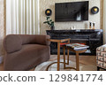 Modern Lounge Area with Armchair and Electric Fireplace 129841774