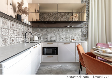 Modern Kitchen with Patterned Tiles and Elegant Dining Area 129841778