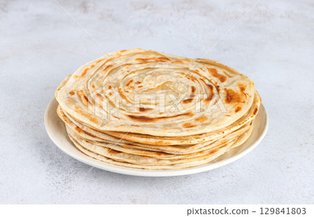 Stack of traditional Indian paratha flatbreads on white background. Indian food. 129841803