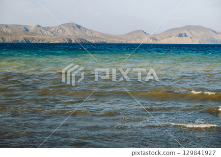 Seascape with mountains and waves forming colorful layers in Koktebel, Crimea 129841927