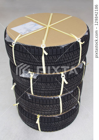 A scene where winter studless tires with wheels ordered from a mail order site arrive in a protected cardboard box. A scene where winter studless tires with wheels ordered from a mail order site arrive in a protected cardboard box. 129842186