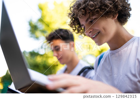 Teens learning lessons and looking involved while reading books 129842315