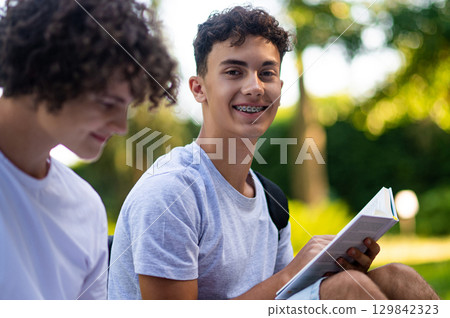 Teens learning lessons and looking involved while reading books Teens learning lessons and looking involved while reading books 129842323