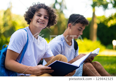 Teens learning lessons and looking involved while reading books Teens learning lessons and looking involved while reading books 129842325