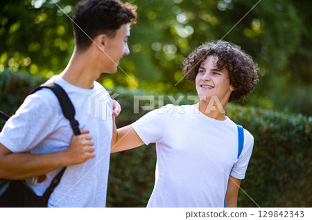 Two teens spending time together and watching something on the phone Two teens spending time together and watching something on the phone 129842343