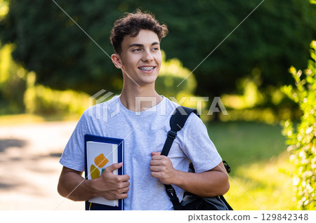 Dark-haired teenager in casual clothes looking good and happy Dark-haired teenager in casual clothes looking good and happy 129842348