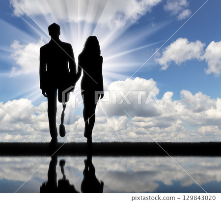 Disabled person with a prosthetic leg, walking with a woman 129843020
