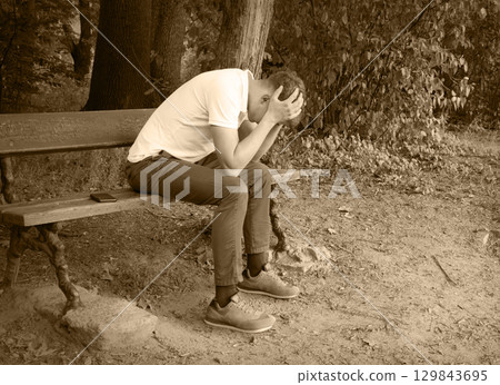 Sad guy on the park bench 129843695