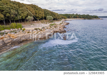 Rocky coastline with clear turquoise water in Istria, Croatia. 129843905