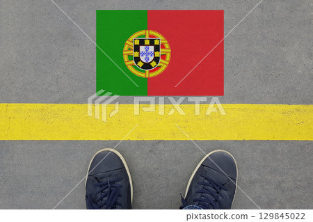 Start on an asphalt road with the Portuguese flag and legs in shoes. Business, Immigration Start on an asphalt road with the Portuguese flag and legs in shoes. Business, Immigration 129845022