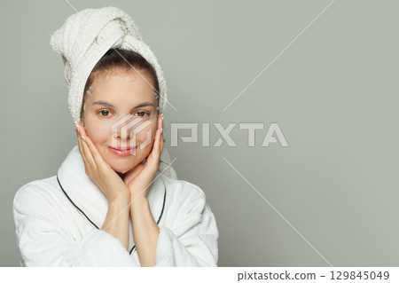 Nice young woman with moisturizing, rejuvenating white fabric sheet mask from her face smiling 129845049