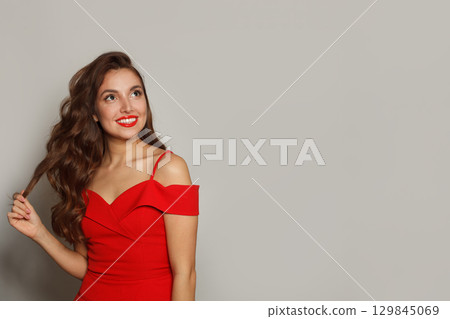 Glorious fashion model woman with shiny skin, wavy hairstyle and red lips makeup on black background Glorious fashion model woman with shiny skin, wavy hairstyle and red lips makeup on black background 129845069