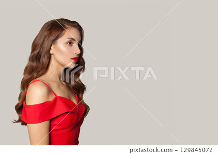 Profile of woman with long hair and make-up on white background. Gorgeous woman with curly hairstyle 129845072
