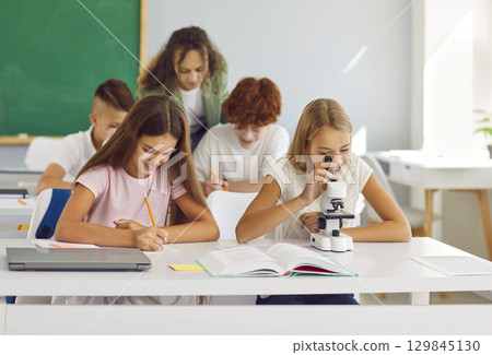 Classroom school study, happy pupils working with microscope discover world of science Classroom school study, happy pupils working with microscope discover world of science 129845130