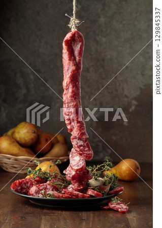 Dry-cured sausages with thyme and pears. 129845337